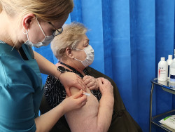 Hoitaja pistää rokotusta asiakkaan käsivarteen. Kuva Jaana Pinson